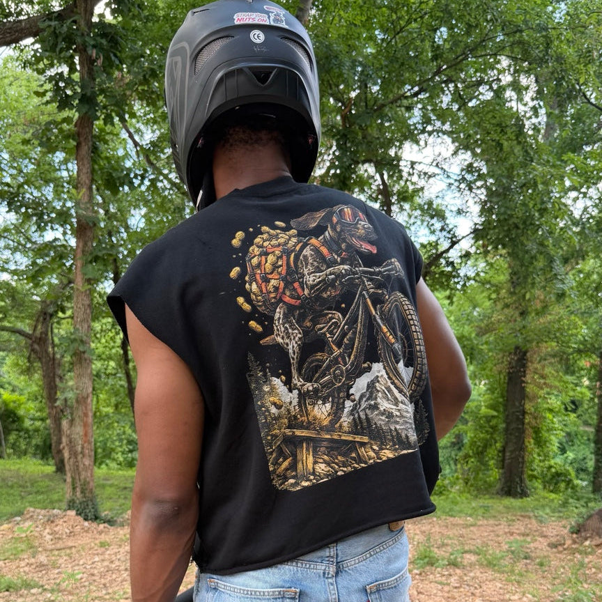 Person riding a bike with a helmet and camouflage-patterned shirt, accompanied by a dog on a leash.