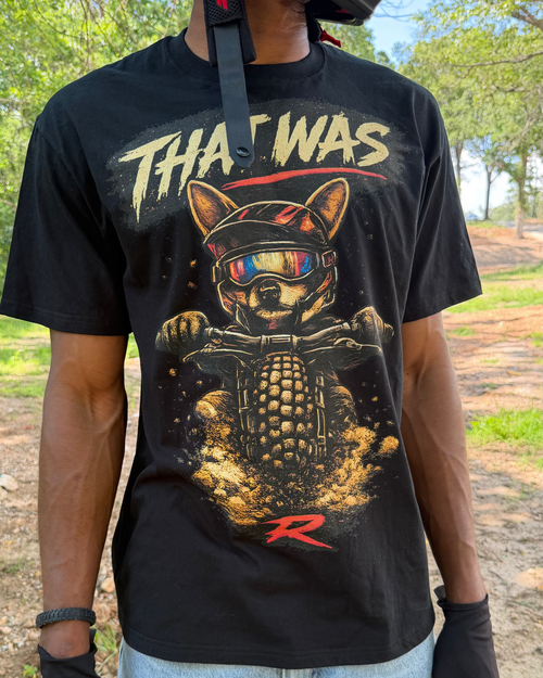 Person wearing a black t-shirt with a graphic design and text outdoors.