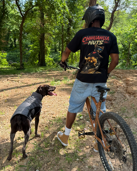 Man on a bike with a dog in a forest